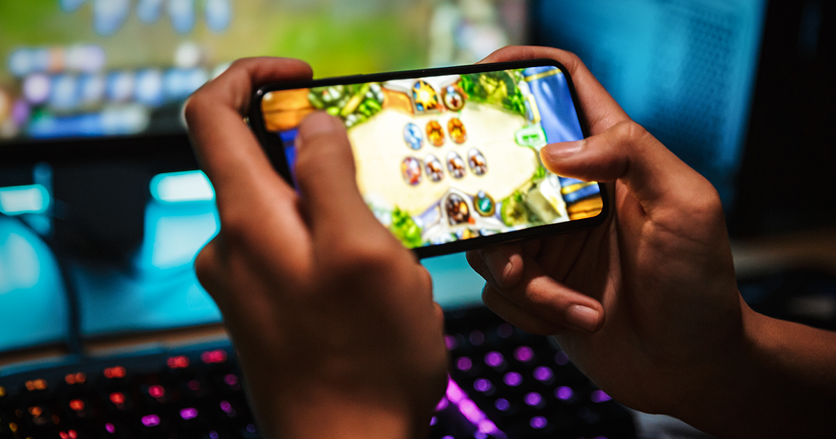 Persona sosteniendo un celular mientras juega un videojuego
